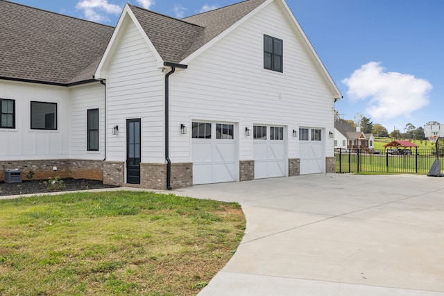 view of side of property featuring a garage, central AC unit, and a lawn