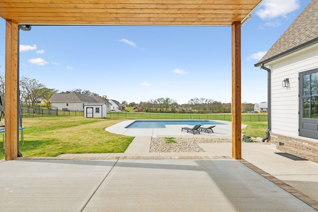 view of swimming pool featuring a storage shed, a lawn, and a patio