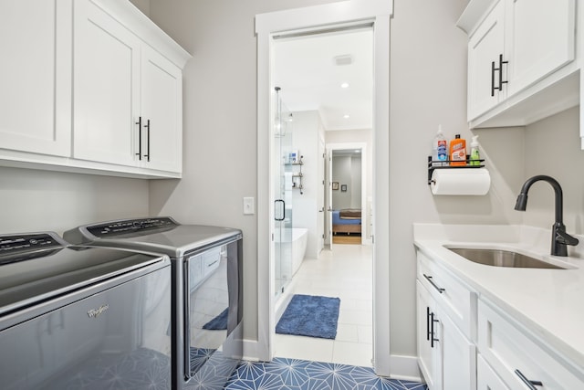 washroom featuring cabinets, washing machine and dryer, tile patterned floors, and sink