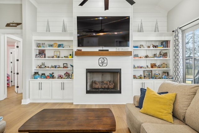 living room featuring a fireplace, light hardwood / wood-style flooring, and lofted ceiling