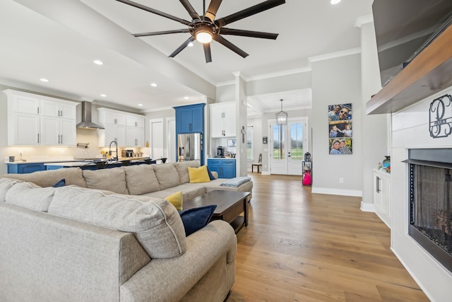 living room featuring ornamental molding, light hardwood / wood-style flooring, and ceiling fan