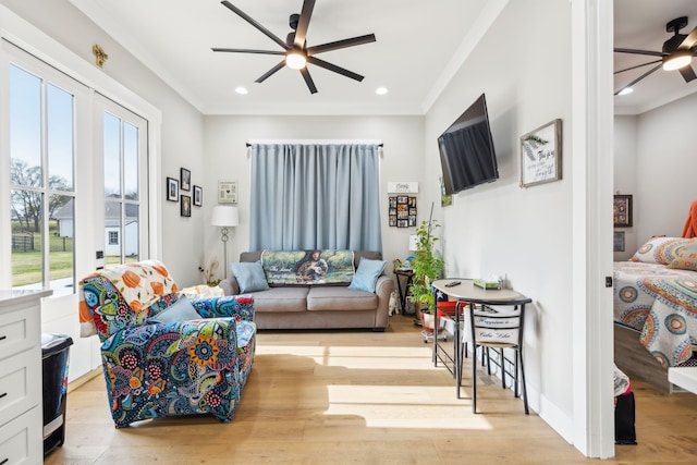 living room featuring light hardwood / wood-style flooring, crown molding, ceiling fan, and plenty of natural light