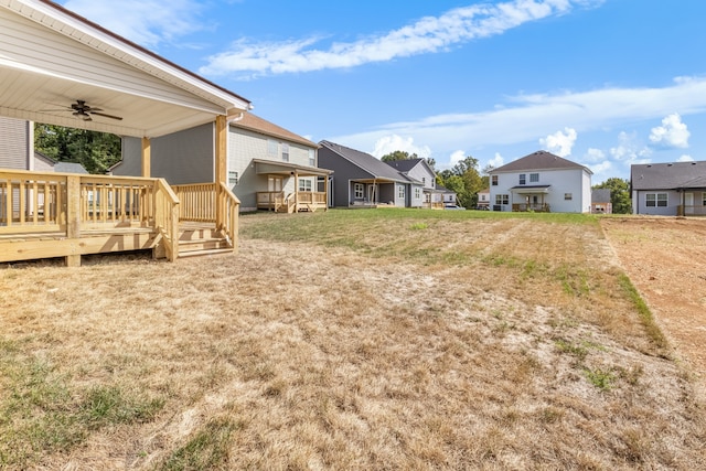 view of yard with a wooden deck and ceiling fan