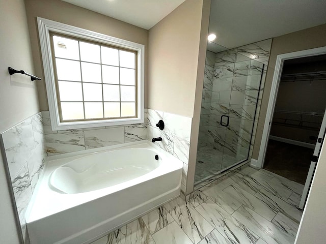 bathroom featuring separate shower and tub and tile walls