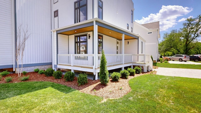 view of home's exterior featuring a lawn and covered porch