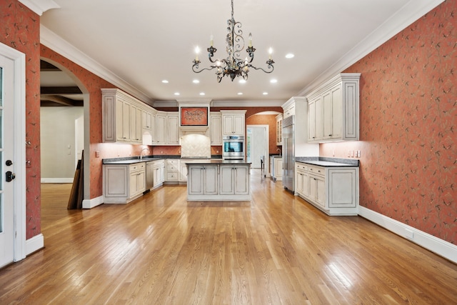 kitchen featuring a center island, backsplash, hanging light fixtures, ornamental molding, and light wood-type flooring