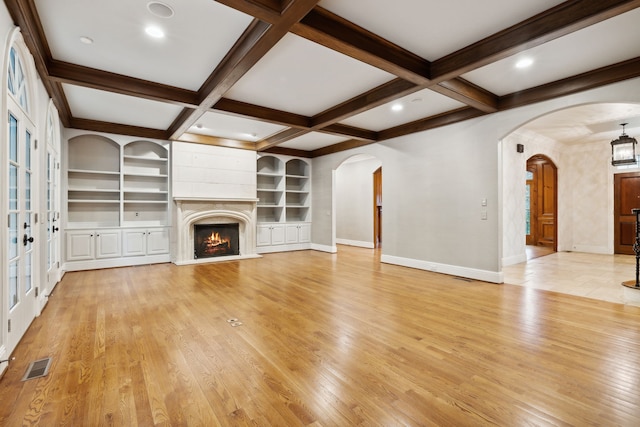 unfurnished living room featuring light hardwood / wood-style floors, built in shelves, beam ceiling, and coffered ceiling