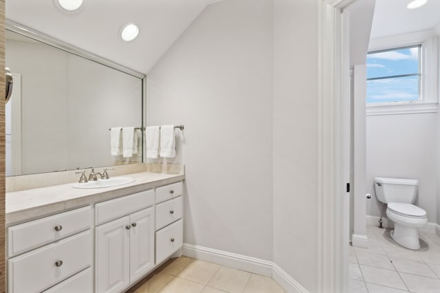 bathroom with tile patterned floors, toilet, vanity, and lofted ceiling