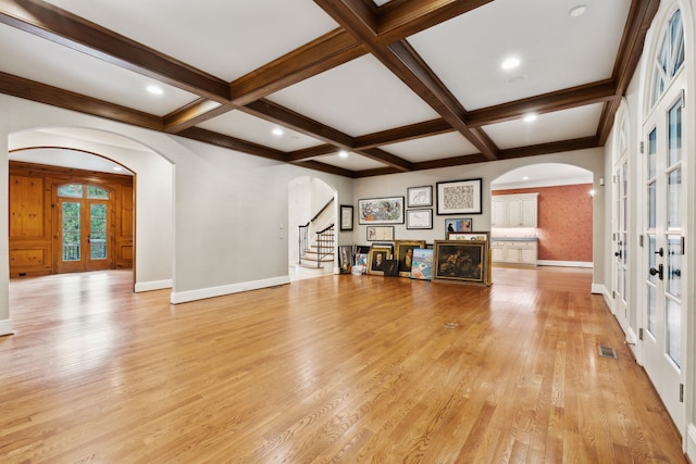 unfurnished living room with french doors, beamed ceiling, and coffered ceiling