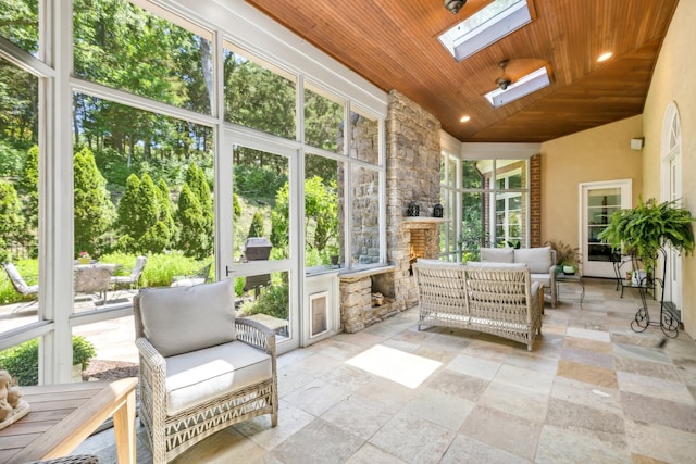 sunroom featuring vaulted ceiling with skylight and wooden ceiling