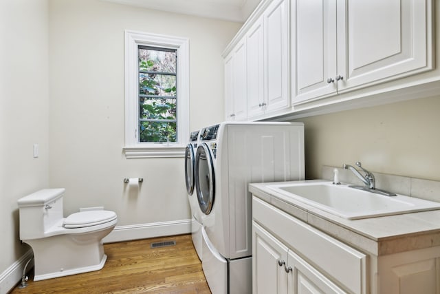 washroom featuring separate washer and dryer, crown molding, light hardwood / wood-style floors, and sink