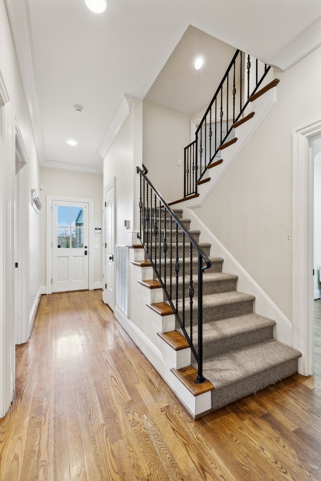 foyer entrance featuring ornamental molding and hardwood / wood-style flooring