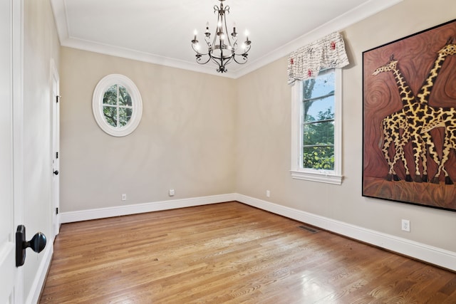 spare room featuring light wood-type flooring, ornamental molding, and plenty of natural light