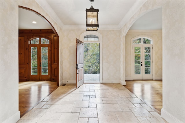 foyer featuring ornamental molding and french doors