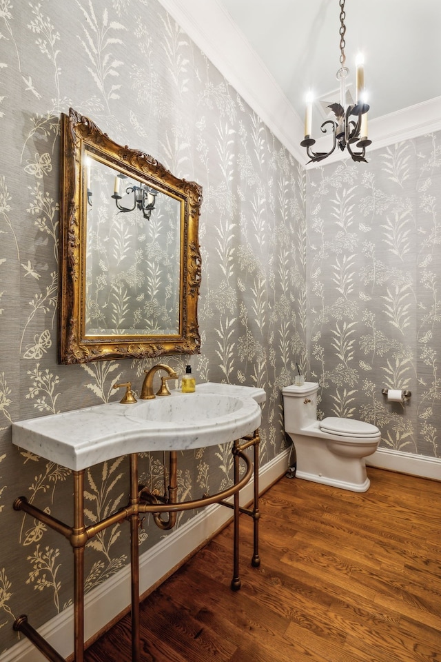 bathroom featuring toilet, a chandelier, wood-type flooring, and ornamental molding