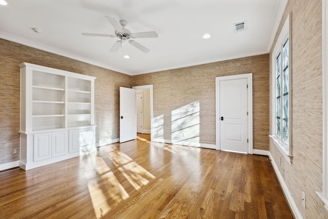 interior space featuring ceiling fan, wood-type flooring, and crown molding