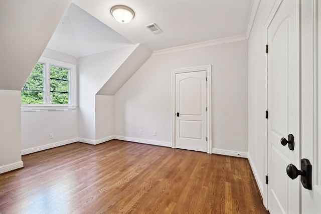 bonus room with hardwood / wood-style floors and vaulted ceiling