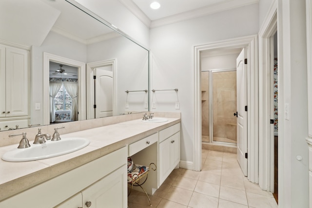 bathroom featuring tile patterned flooring, crown molding, a shower with shower door, and vanity