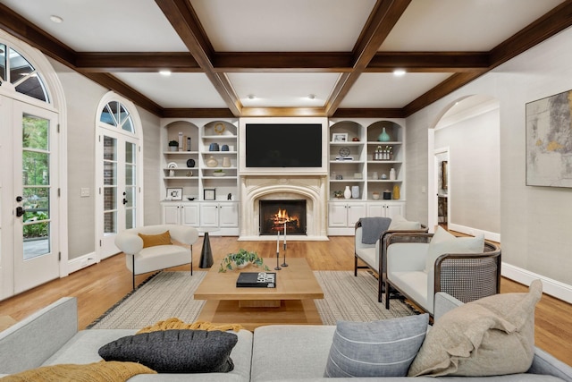 living room featuring light hardwood / wood-style floors, beam ceiling, and coffered ceiling