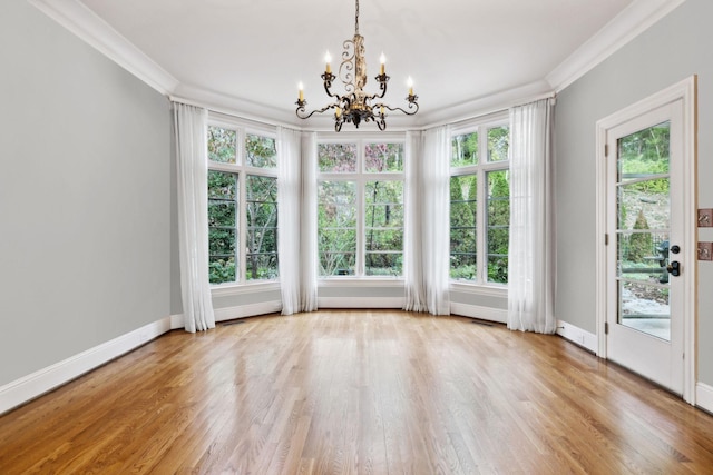 interior space with light wood-type flooring, an inviting chandelier, and ornamental molding