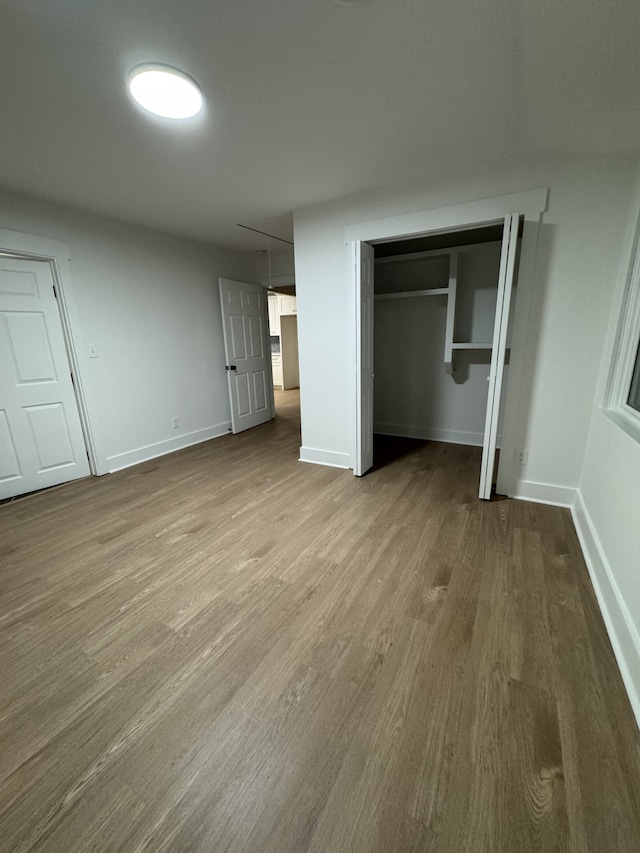 unfurnished bedroom with wood-type flooring and a closet