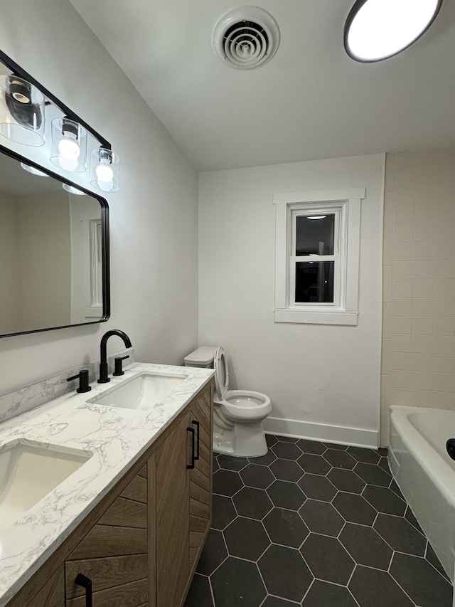 bathroom featuring vanity, tile patterned floors, and toilet