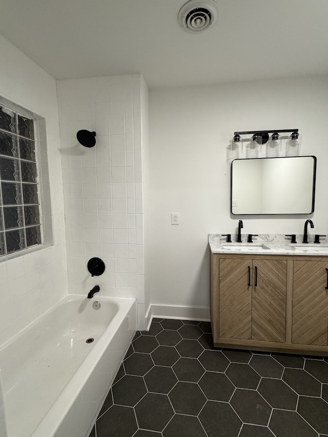 bathroom with tile patterned flooring, vanity, and tiled shower / bath combo