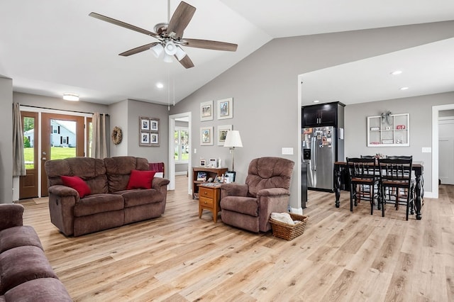 living room with plenty of natural light, light hardwood / wood-style floors, ceiling fan, and vaulted ceiling