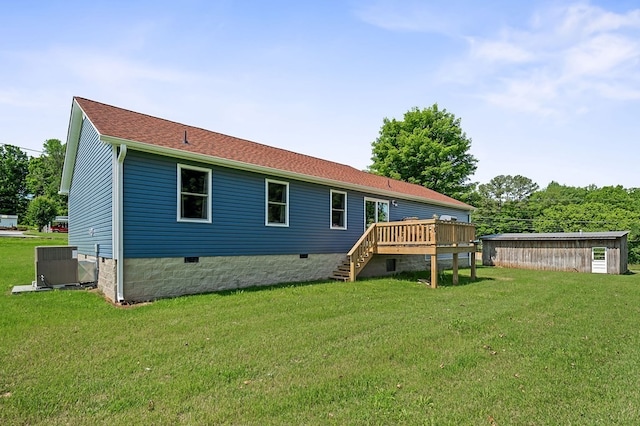 back of house featuring a storage shed, a lawn, central AC, and a deck