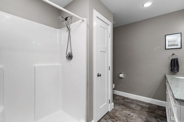 bathroom with walk in shower, vanity, and toilet