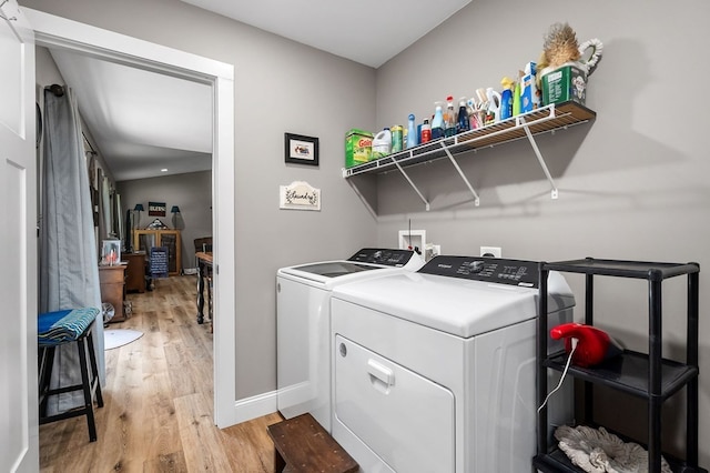 laundry area featuring washer and clothes dryer and light hardwood / wood-style floors