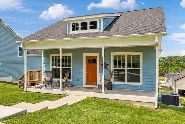 back of house featuring central air condition unit, a yard, and covered porch