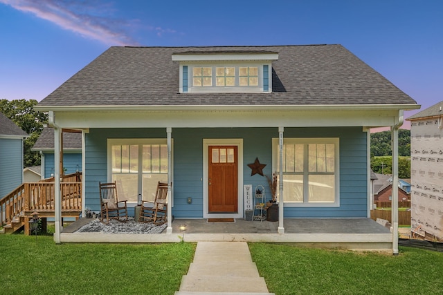 view of front facade with a lawn and covered porch