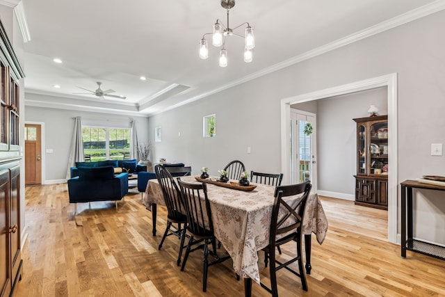 dining area featuring ceiling fan with notable chandelier, light hardwood / wood-style flooring, and crown molding