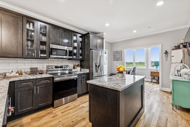 kitchen featuring light hardwood / wood-style floors, light stone counters, and appliances with stainless steel finishes