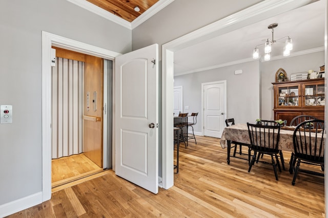 dining room featuring light wood-type flooring, a chandelier, and crown molding