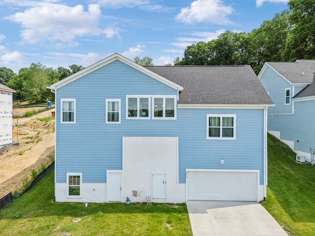 rear view of house featuring a garage and a yard