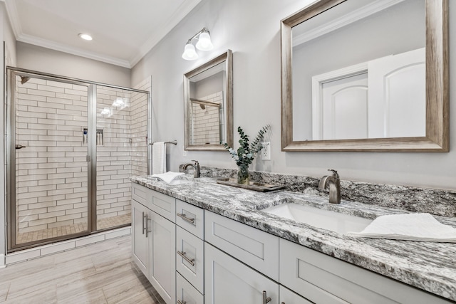 bathroom with a shower with door, vanity, and ornamental molding