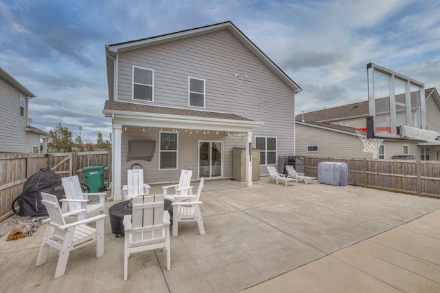 back of property with an outdoor fire pit and a patio area