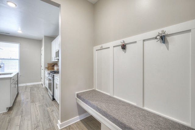 mudroom featuring sink and light hardwood / wood-style flooring