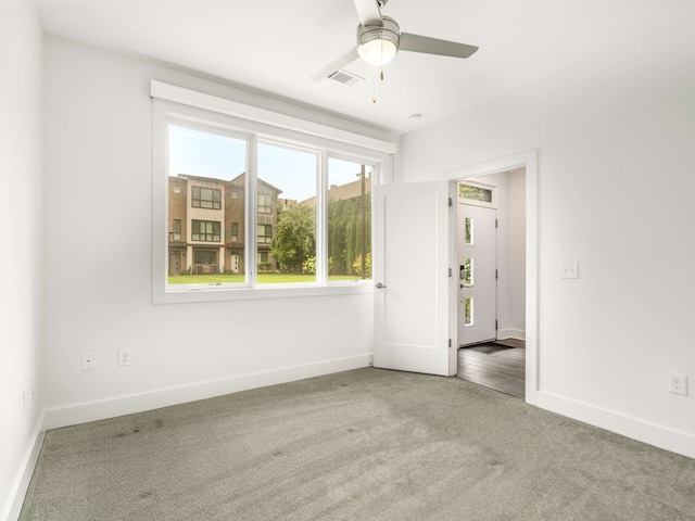 spare room with ceiling fan and carpet