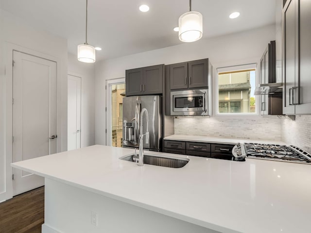 kitchen featuring hanging light fixtures, dark hardwood / wood-style flooring, kitchen peninsula, and appliances with stainless steel finishes