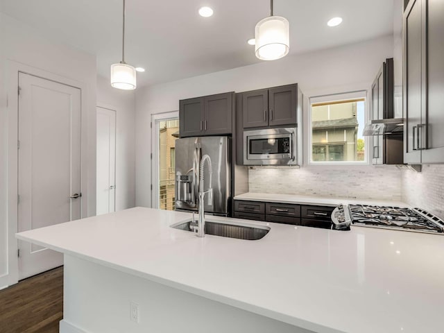kitchen with appliances with stainless steel finishes, a sink, tasteful backsplash, light countertops, and recessed lighting