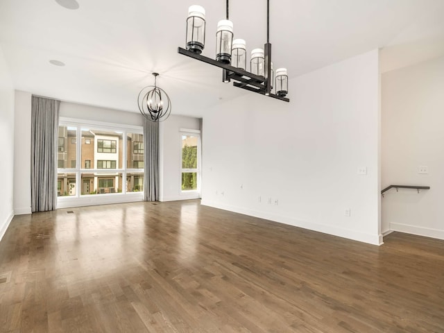 unfurnished dining area with a notable chandelier and dark hardwood / wood-style floors