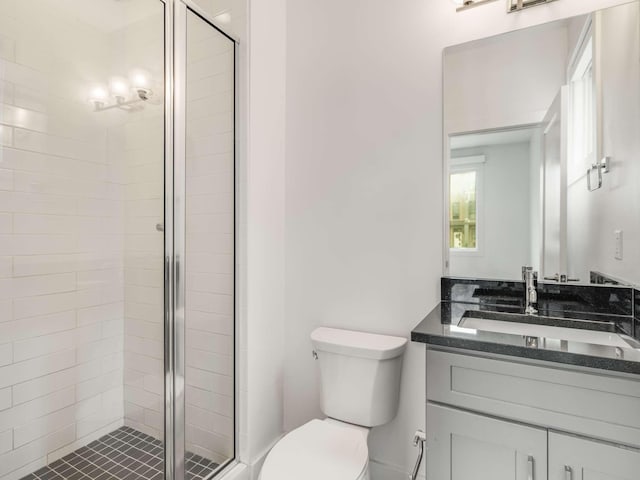 bathroom with a stall shower, toilet, and vanity