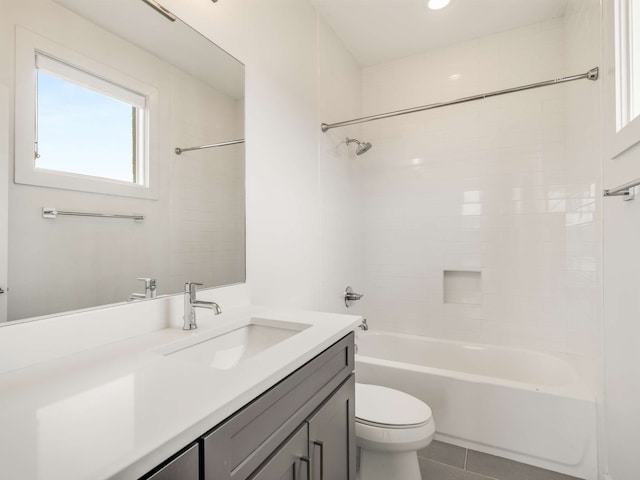 full bathroom with vanity, tile patterned flooring, tiled shower / bath, and toilet