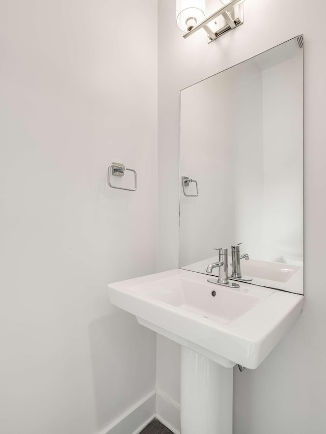 bathroom featuring baseboards and a sink