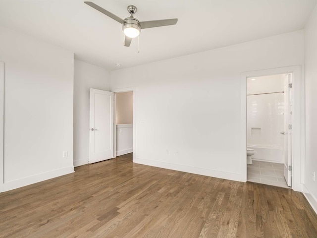 unfurnished bedroom with hardwood / wood-style floors, ensuite bathroom, and ceiling fan