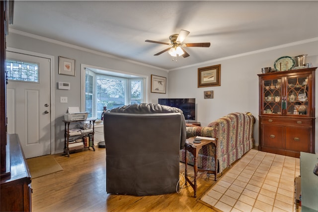 living room featuring hardwood / wood-style flooring, ceiling fan, and crown molding