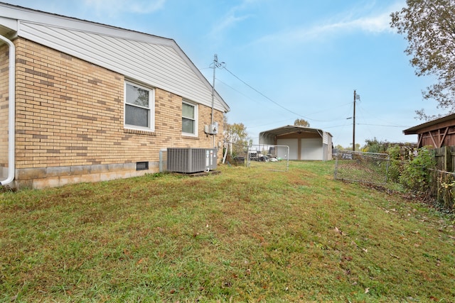 view of yard featuring an outbuilding, central air condition unit, and a garage